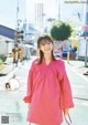 A woman in a pink dress is posing for a magazine.